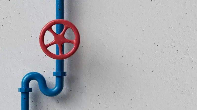 Red shut-off valve handle on a blue water pipe